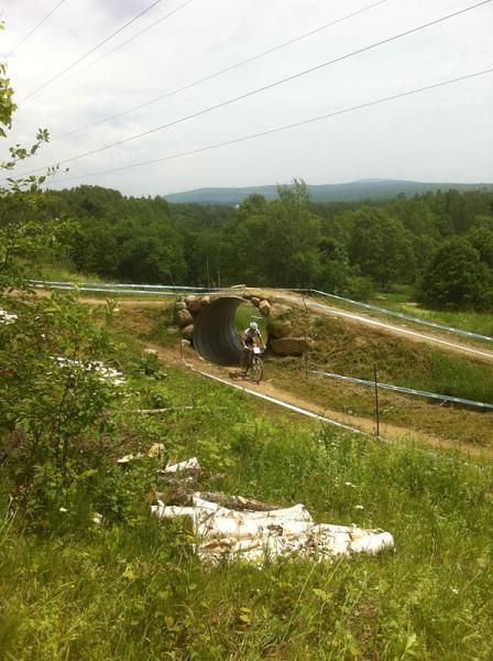 A rider goes through a culvert that is used for a course crossover