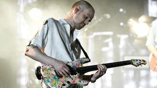 Adam Hann plays his Ernie Ball Music Man John Petrucci signature model with the Jackson Pollock-inspired finish onstage with the 1975, as the band play Grant Park, Chicago, on the 2023 Lollapalooza tour.