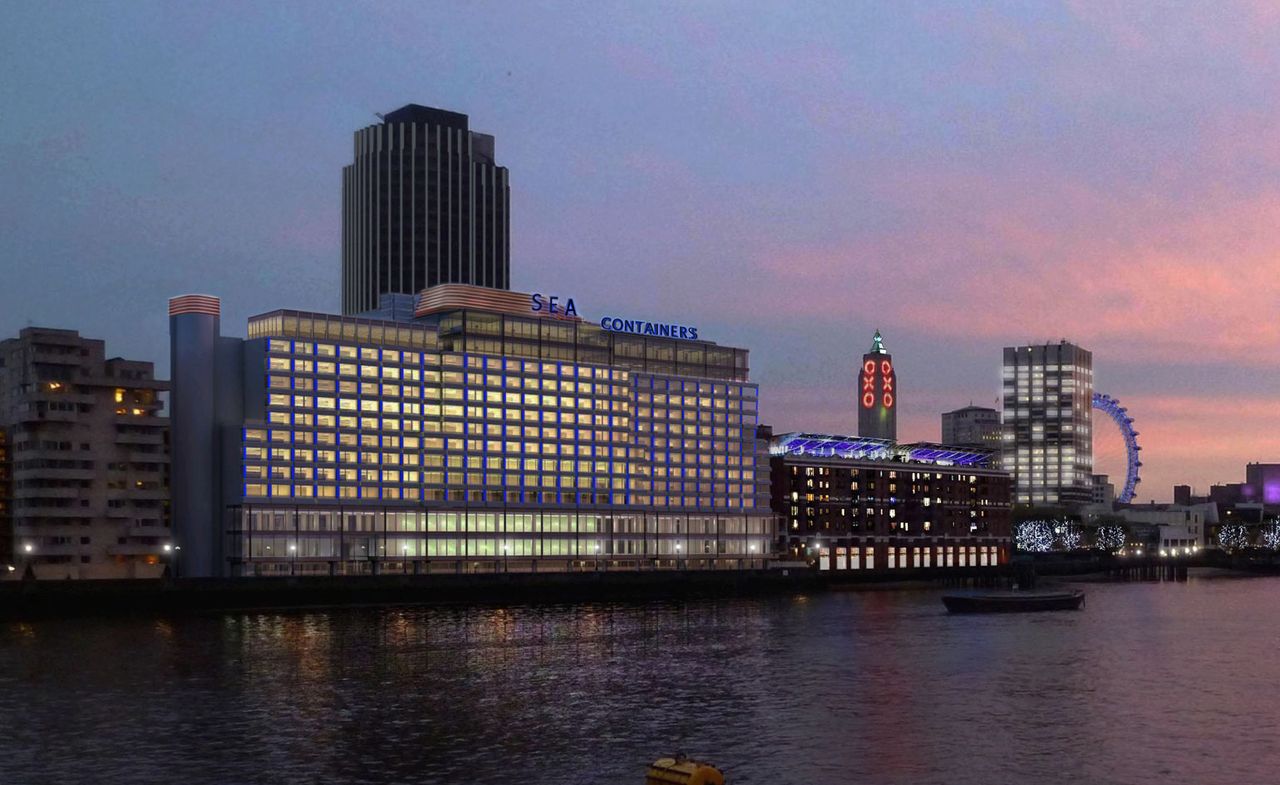 Outside look at the Sea Containers hotel from the river. Wide building, with floor-to-ceiling windows and a &quot;Sea Containers&quot; sign at the top. We can see other buildings in the distance, as well as the London Eye.