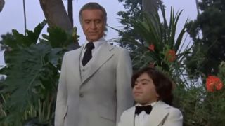 Ricardo Montalban as Mr. Roarke and Hervé Villechaize as Tattoo in white suits waiting for guests on Fantasy Island