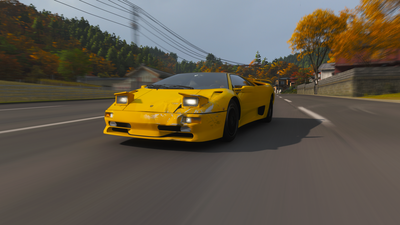 Forza Horizon 6 best cars: A yellow Lamborghini Diablo SV racing down street outside Tokyo.