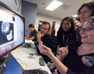 New Horizons mission team members (from left) Kirby Runyon, Rajani Dhingra, Mallory Kinczyk and Kelsi Singer discuss the two primary objects of the simulated Ultima Thule system.