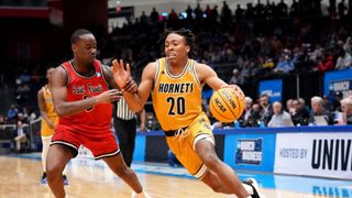 The Alabama State Hornets' TJ Madlock dribbles the ball past Saint Francis Red Flash's Daemar Kelly at March Madness 2025