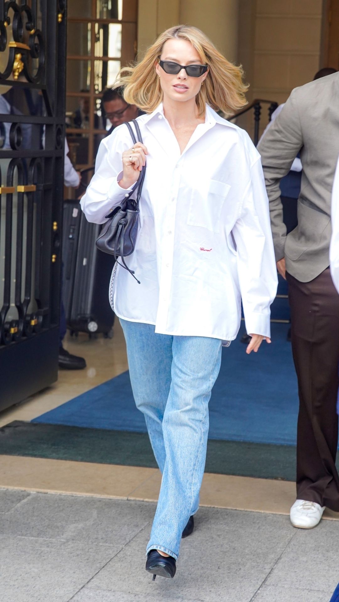 margot robbie wearing a white shirt and jeans