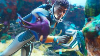 A young man scanning a reef while looking at an alien fish during the trailer for Subnautica 2.