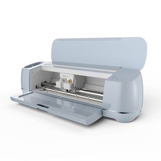 The best Cricut machines; an off-white craft cutting machine with its lid and draw open so you can see its cutting blade