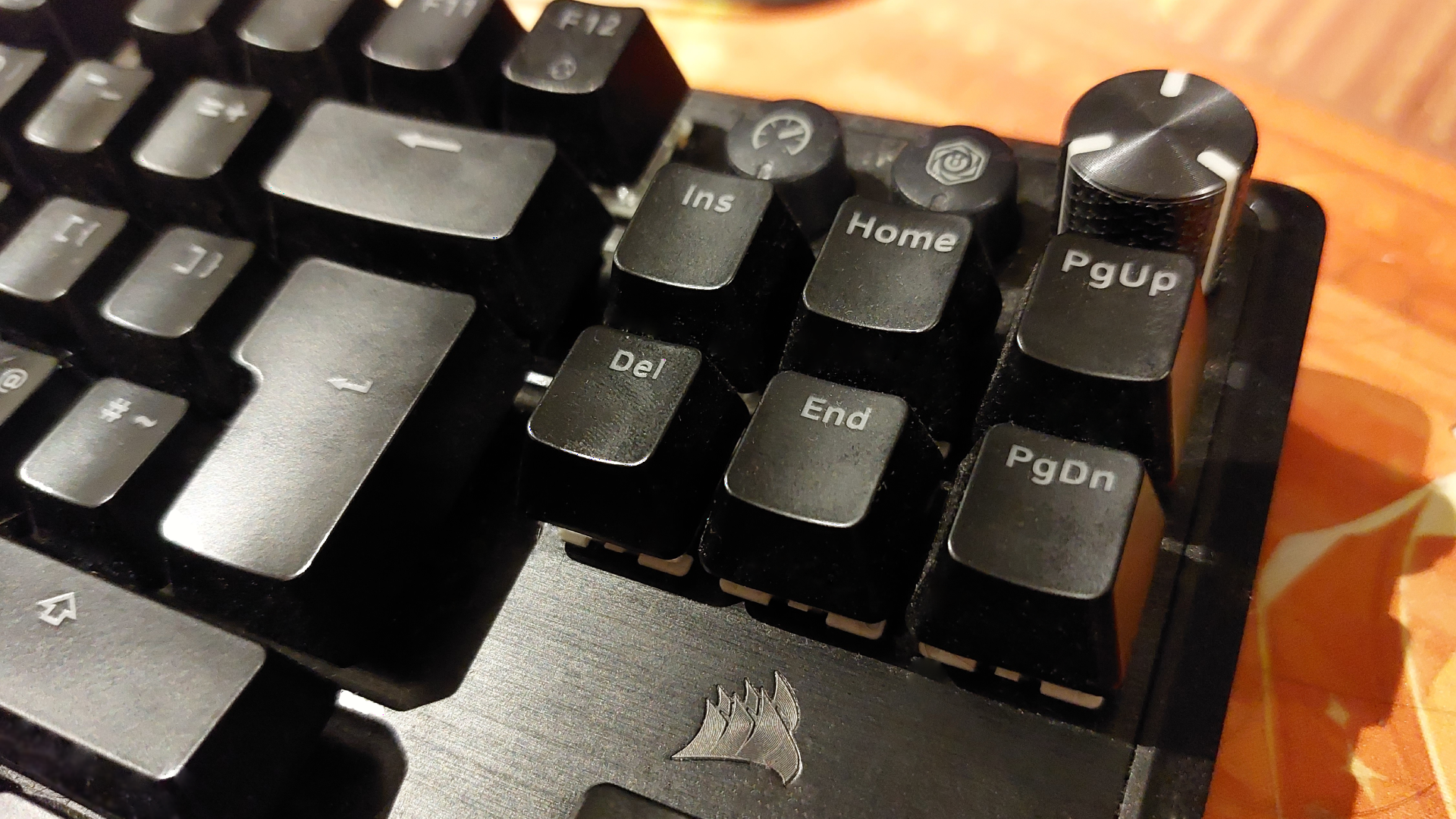 A photograph of a gaming keyboard on a wooden desk.