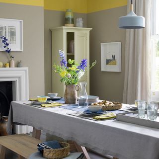 yellow flower vase with grey coloured table linen and glasses