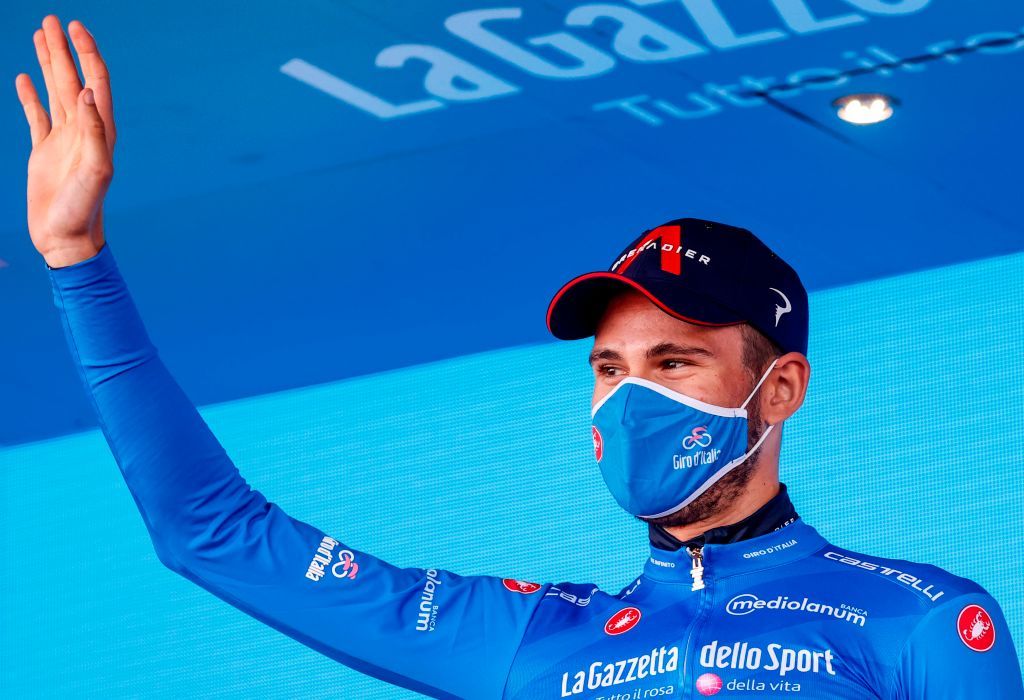 Team Ineos rider Italys Filippo Ganna wearing a face mask celebrates on the podium after receiving the azzurra jersey in the 8th stage of the Giro dItalia 2020 cycling race a 200kilometer route between Giovinazzo and Vieste on October 10 2020 Photo by Luca Bettini AFP Photo by LUCA BETTINIAFP via Getty Images
