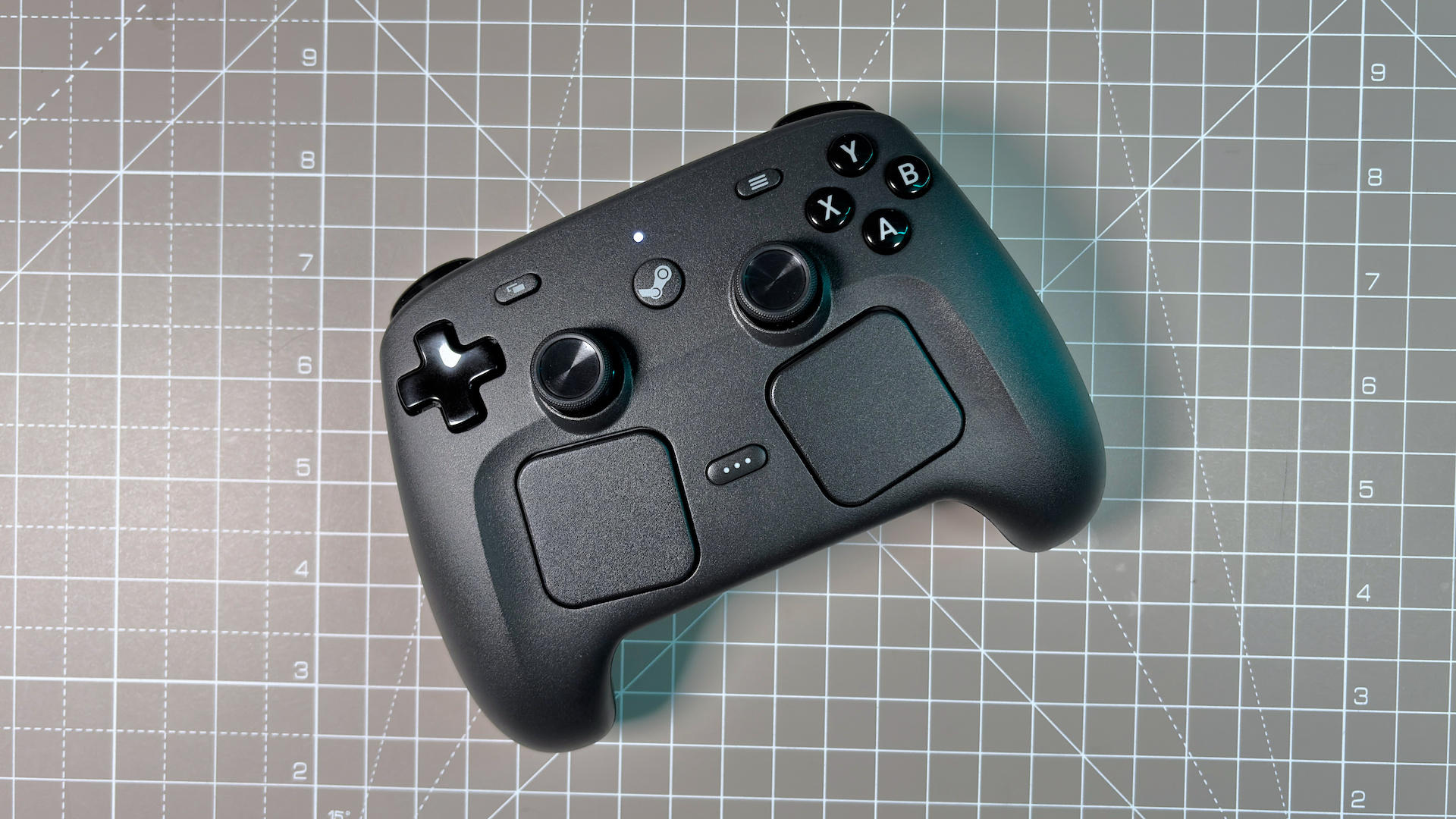 The Steam Controller on a desk during a teardown, with various parts removed.