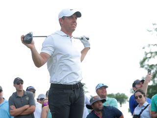 Rory McIlroy holding a golf club in two hands across his shoulders