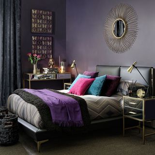 bedroom with deep purple wall and mirror drawer