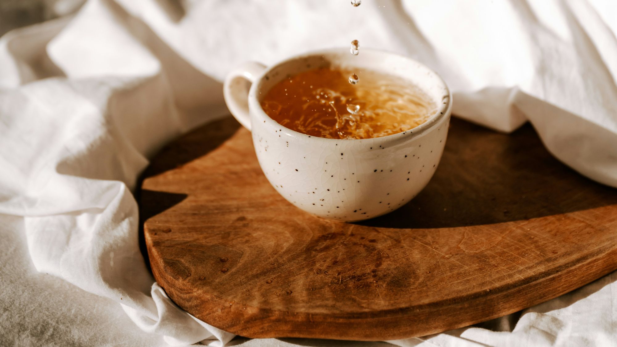 cup of tea on a white bedsheet