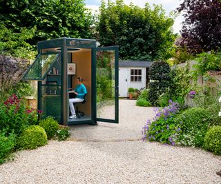 small aluminium, glass and timber hexagonal office pod in garden