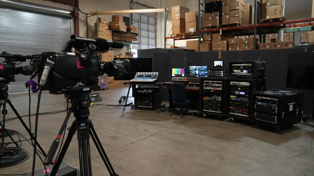 A camera focused on a production set and mixing board.