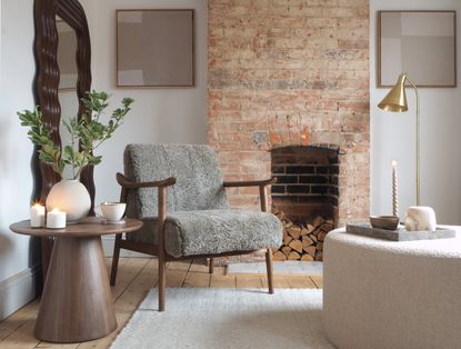 Minimalist living room with a grey boucle chair and brick fireplace