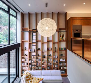 A living room with a floor to ceiling built in library unit