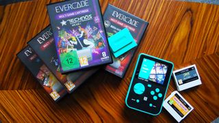 Capcom and Taito Super Pocket handhelds next to Evercade games on woodgrain table