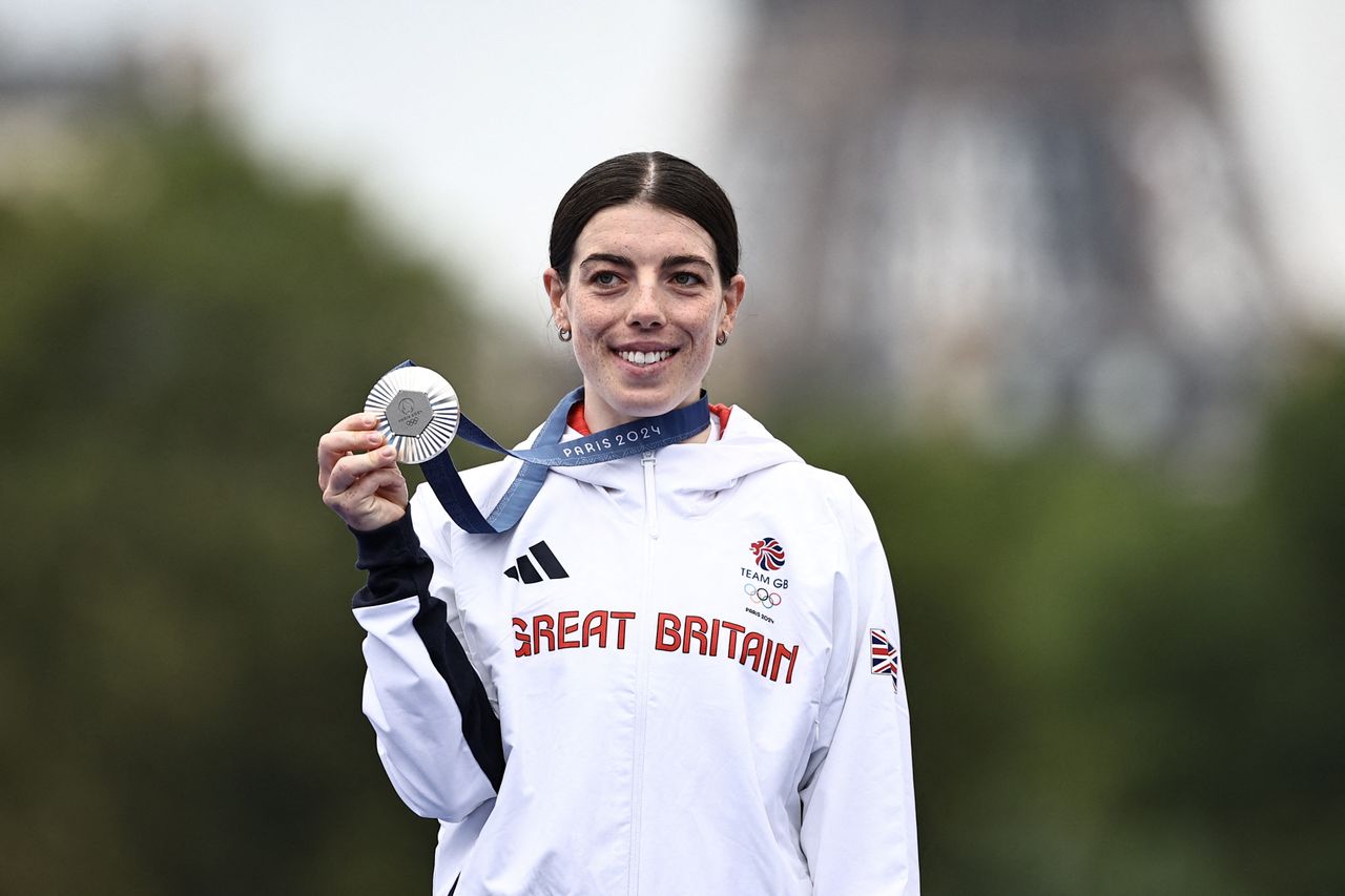 Anna Henderson holding a silver Olympic medal