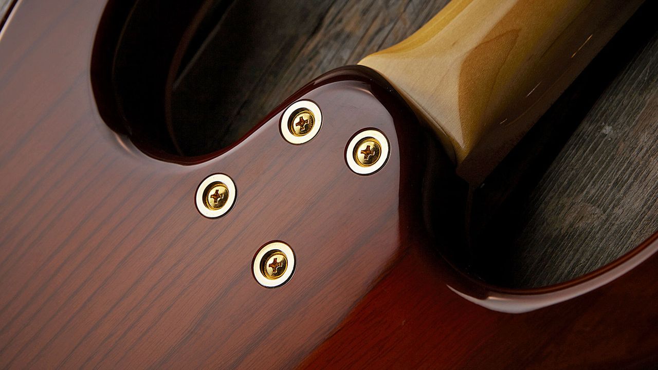 The C-shape profile maple neck is joined to the body by these four recessed screws