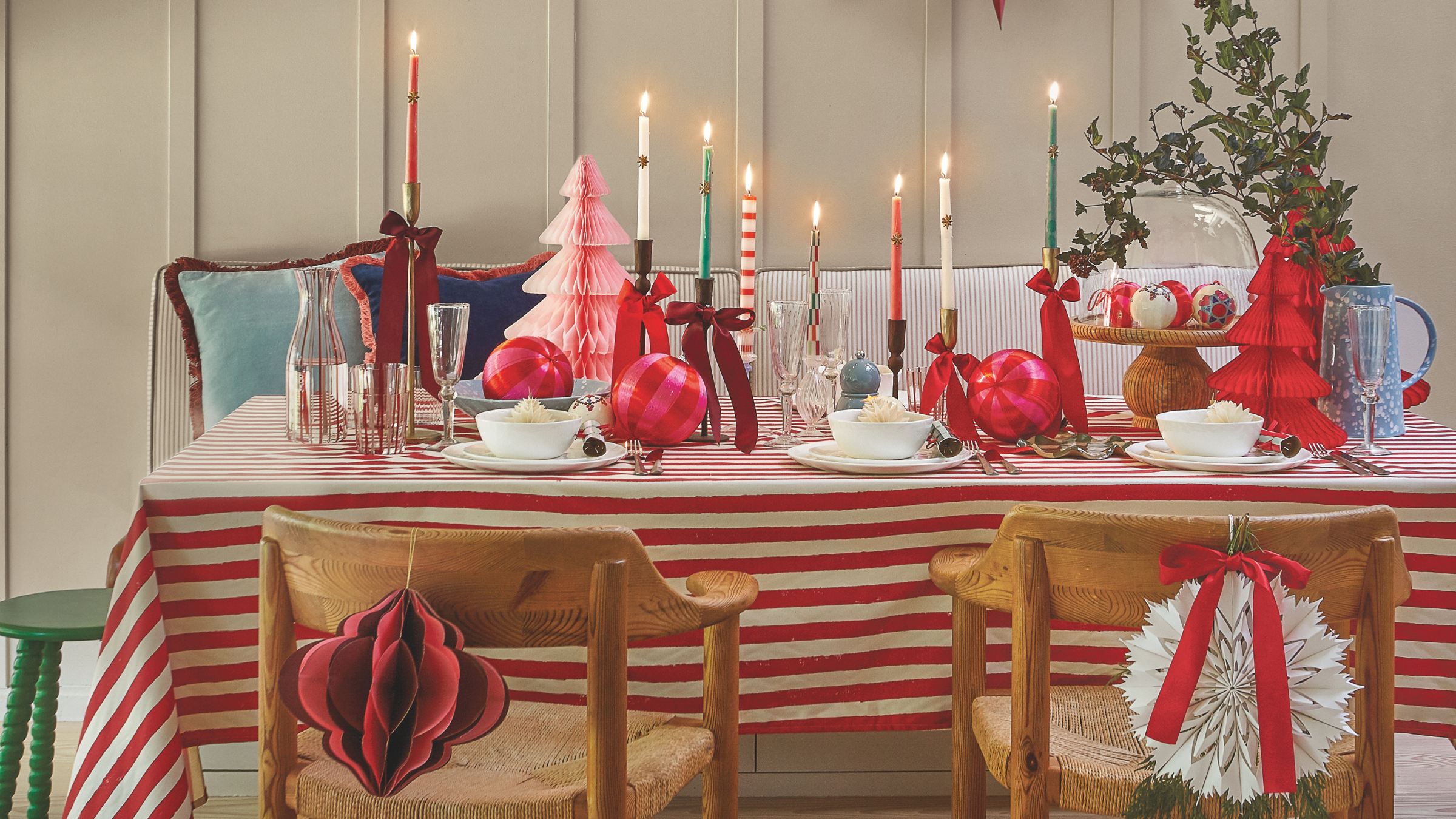Striped tablecloth. candles and paper trees on Christmas tablescape.