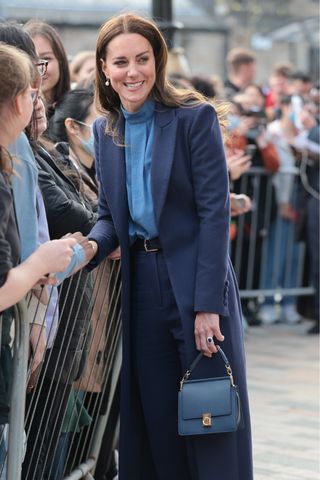 Kate Middleton carries a blue handbag as she meets students during a visit to the University of Glasgow on May 11, 2022 in Glasgow, Scotland.