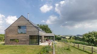 timber clad self build in large field