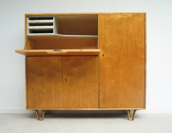 A birch wood multi-compartment cabinet with one compartment door open resting downwards to create a shelf.