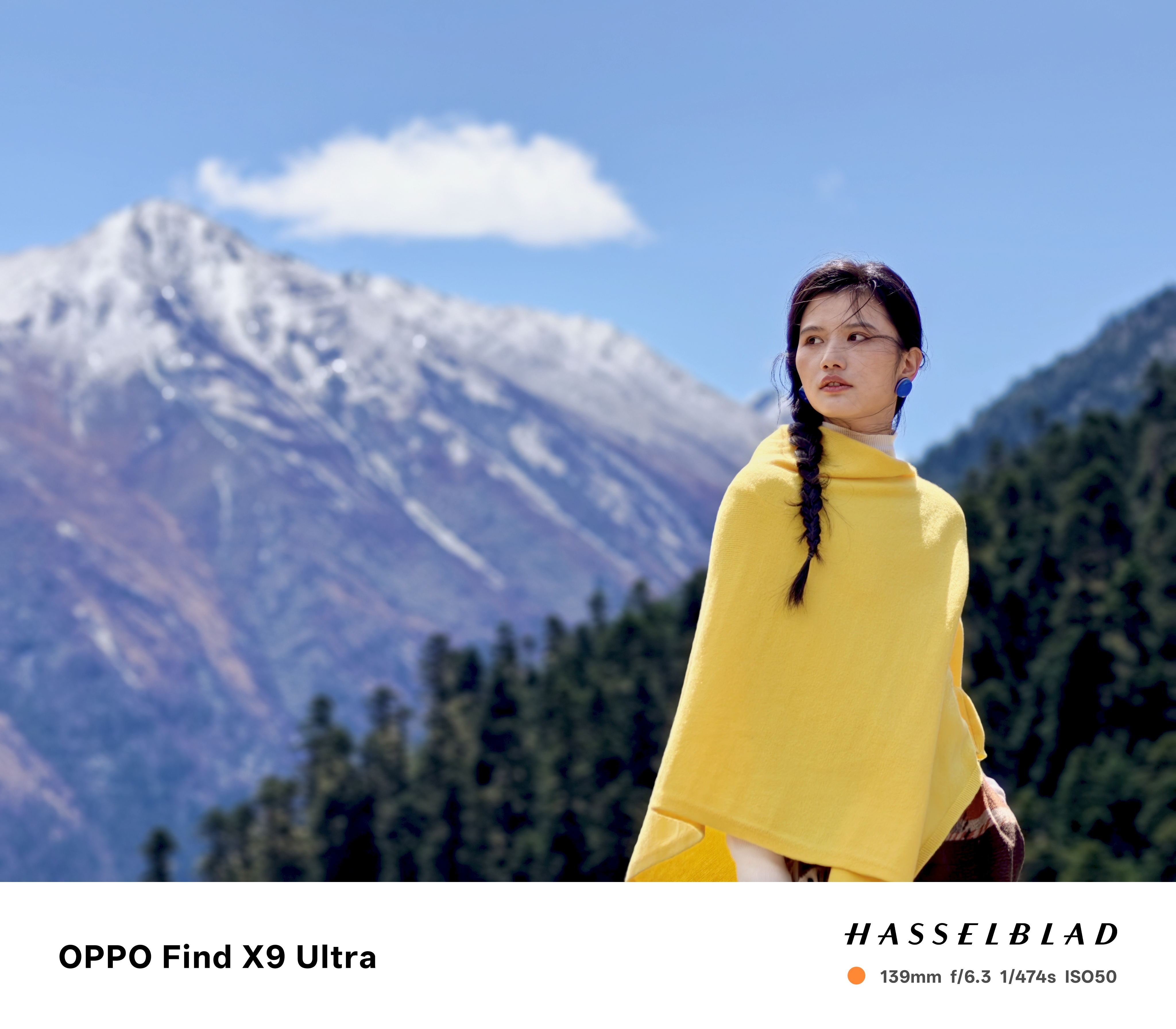 Woman in yellow shawl in front of a snowy mountain