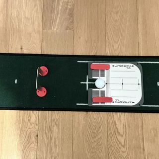 The PuttOUT Mirror Trainer With Gate lying on the floor