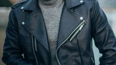 Man wearing leather jacket and gray sweater