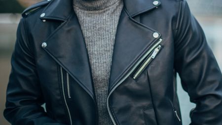 Man wearing leather jacket and gray sweater