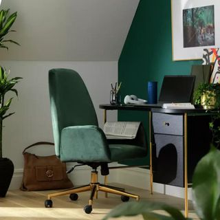 A green velvet office chair with gold detailing