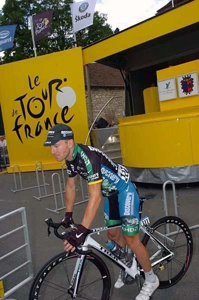 Levi Leipheimer uses one foot to pedal back from the sign-in.
