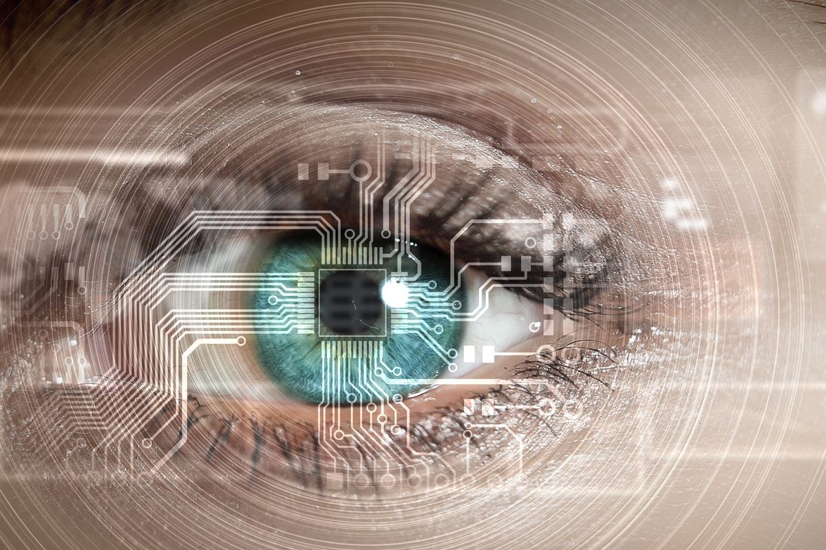 Close up of a human eye overlaid with computer circuit graphics.