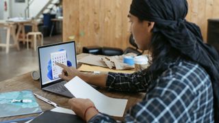 A person using a touchscreen Windows 11 laptop.