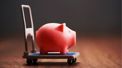 A piggy bank on a hand truck.