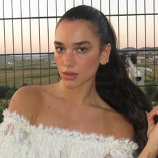 Dua Lipa pairs lace-trimmed lingerie with a track jacket for pre-fall 2026's sportif trend
