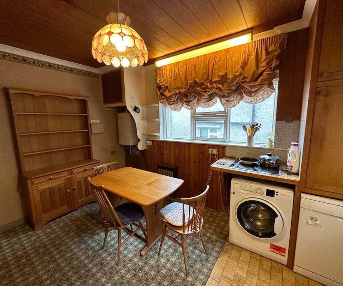A kitchen with wooden fixtures and small dining table