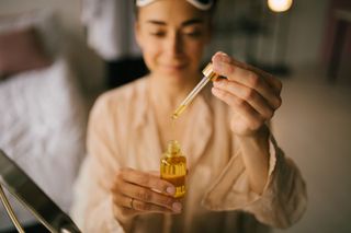 close up of a woman applying one of the best facial oils