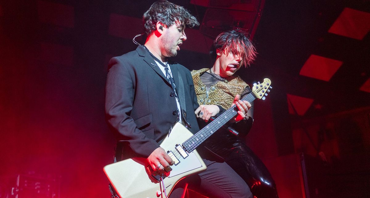 Adam Harrington plays an Ernie Ball Music Man St Vincent Goldie onstage with Yungblud, who is in full-on punk mode with his tongue sticking out.