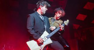 Adam Harringont plays an Ernie Ball Music Man St Vincent Goldie onstage with Yungblud, who is in full-on punk mode with his tongue sticking out.