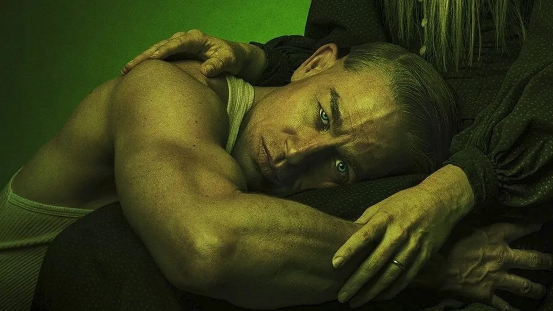 Charlie Hunnam as Ed Gein, kneeling in the lap of a woman with long white hair