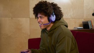 Official promo image by Turtle Beach of a model wearing the new purple Stealth 600 Gen 3 gaming headset.