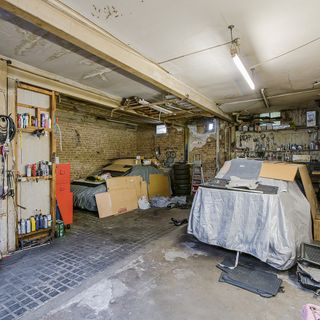 garage room with concrete flooring and brick walls