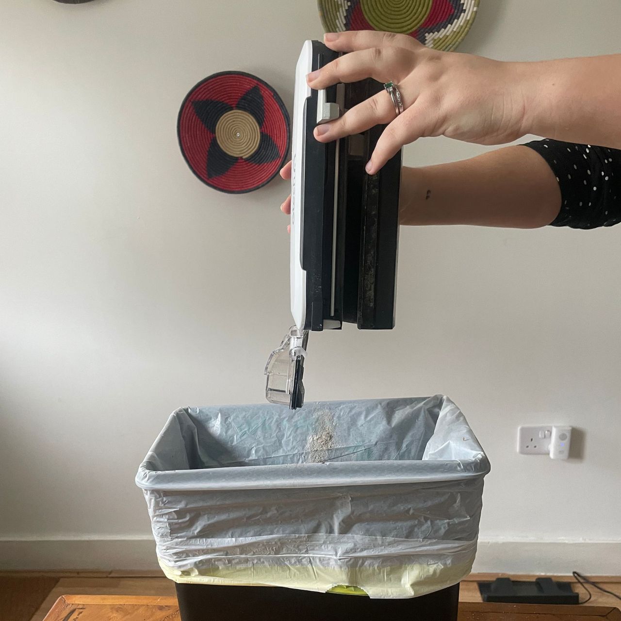 Gtech AirRam 3 emptying over a kitchen bin