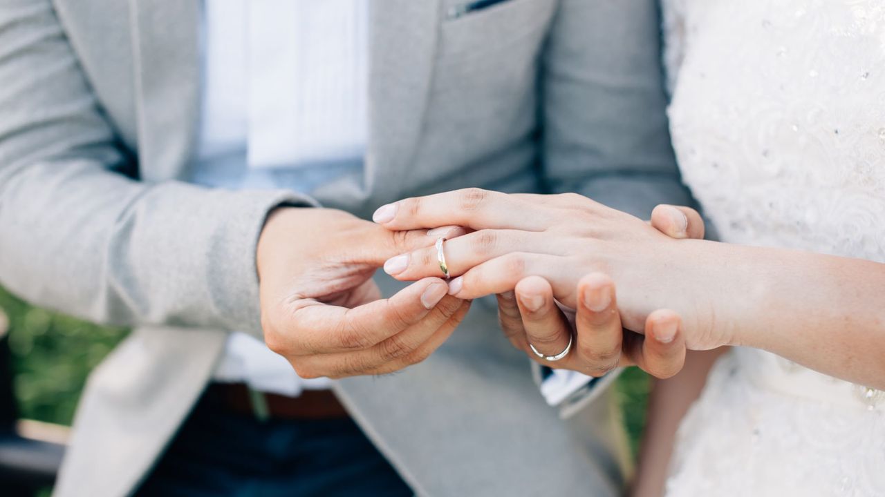 A couple exchanges rings at their wedding