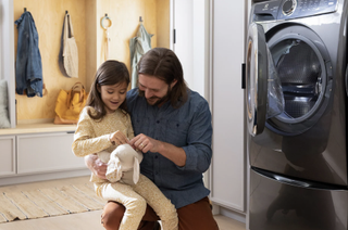 Man and daughter next to an open washing machine