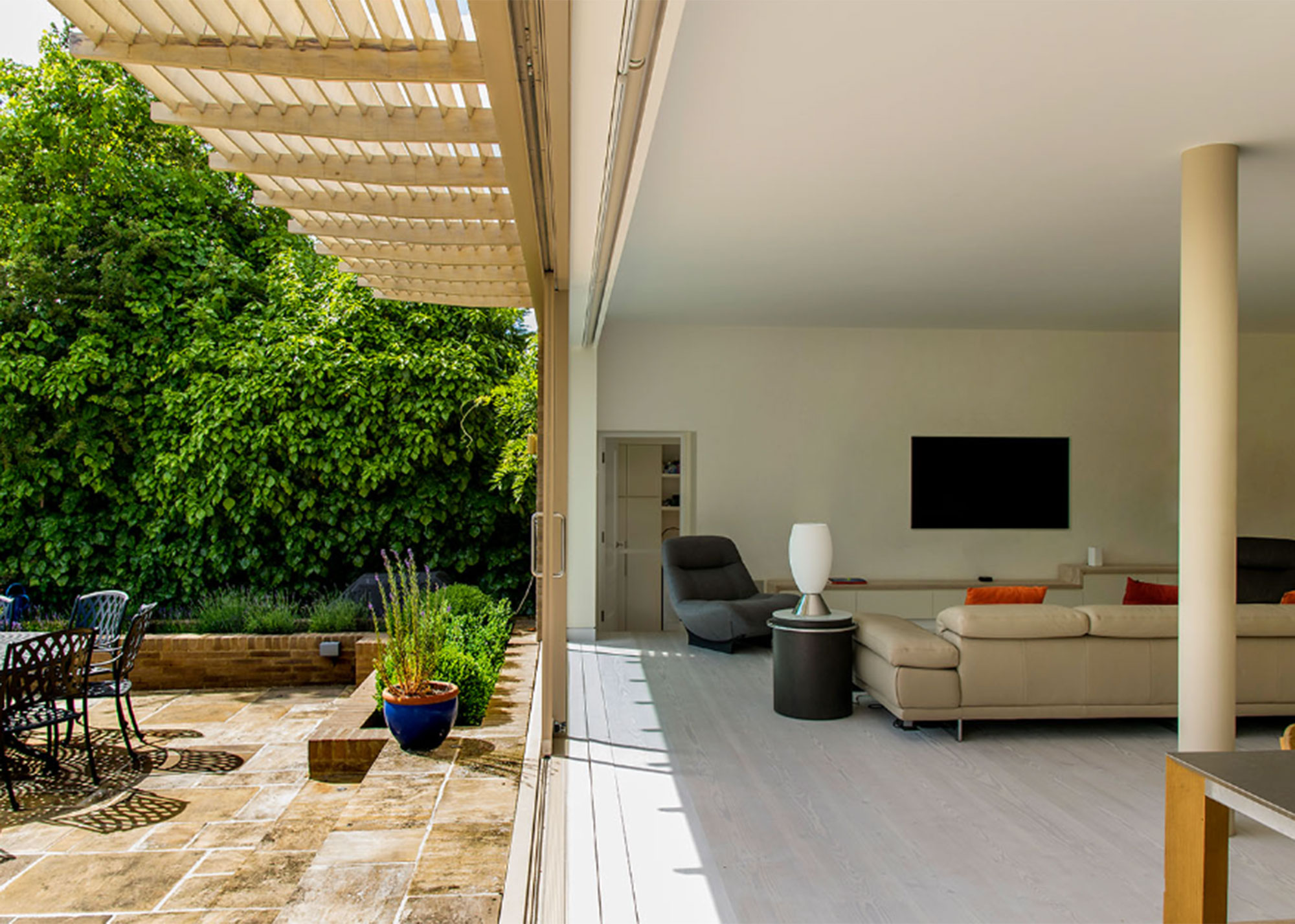 modern living room with sliding doors to patio area and wooden brise soleil