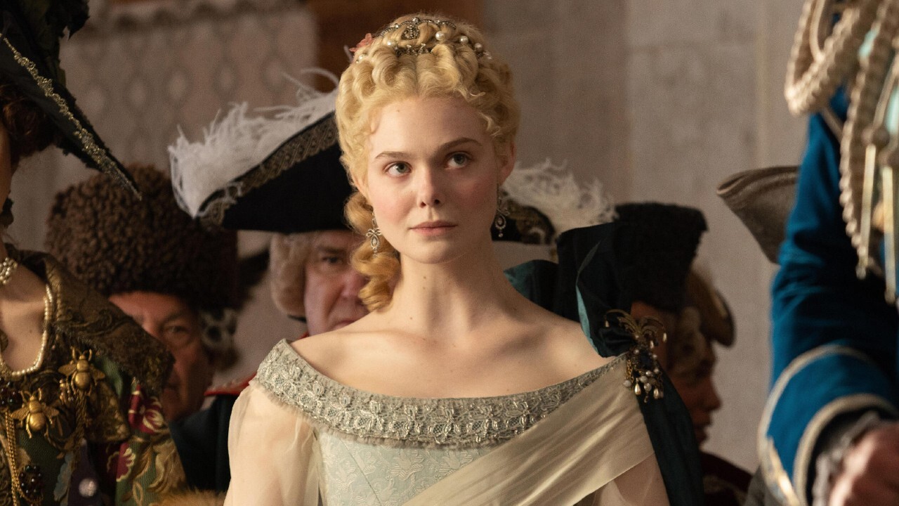Elle Fanning sits on the throne with a wry smile in The Great.